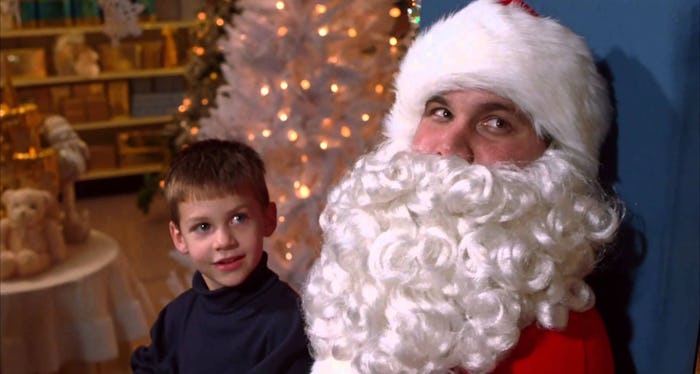 A kid taking a photo with Santa Claus