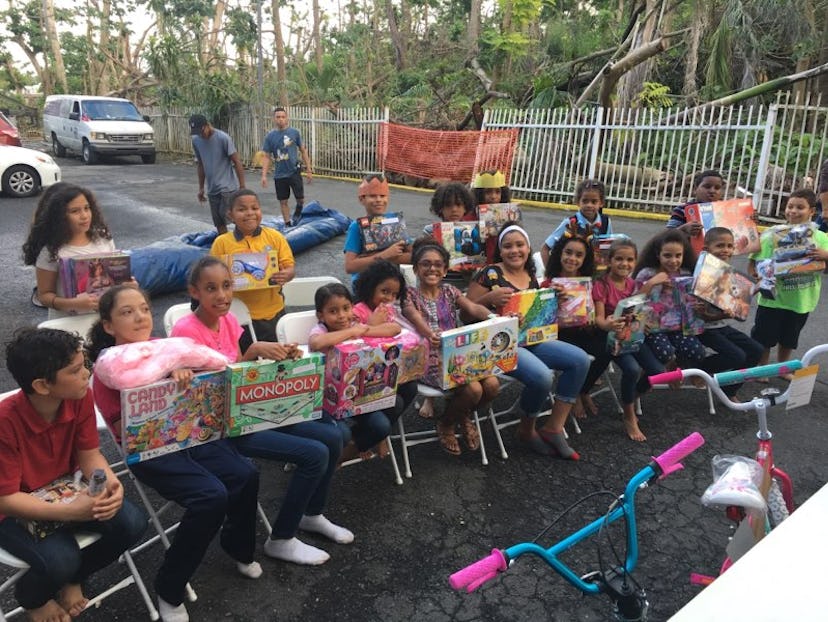 Kids posing for a photo with gifts from Adopt A Family In PR