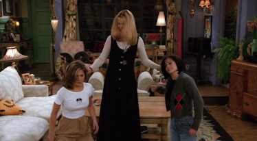 Phoebe holds Rachel's and Monica's ears in their living room in 'Friends.'