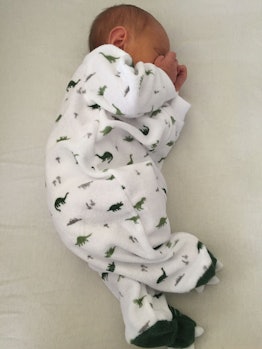 Shannon Bresher Shea's newborn baby sleeping in a dinosaur onesie.