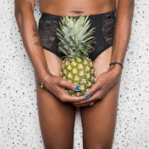 A person holds a pineapple in front of their crotch. Doctors explain how IUDs can affect your period...