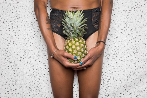 A person holds a pineapple in front of their crotch. Doctors explain how IUDs can affect your period...