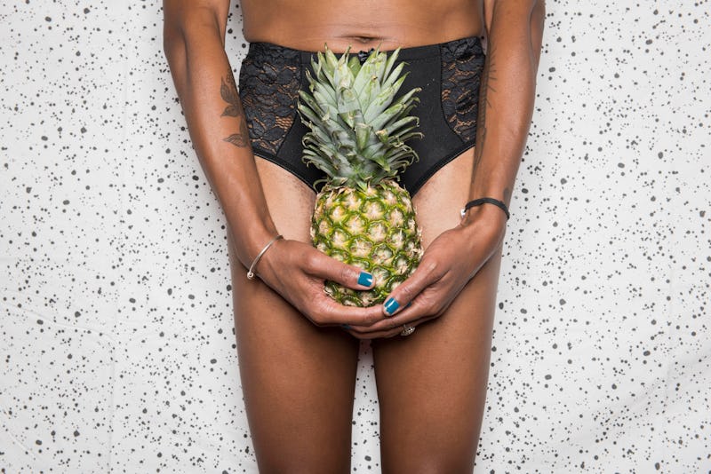 A person holds a pineapple in front of their crotch. Doctors explain how IUDs can affect your period...