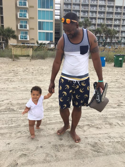 A father walking with his toddler at the beach
