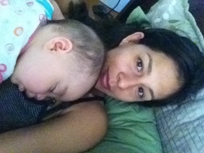 A mother lying in bed with her newborn baby