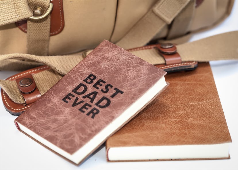 A notebook with 'Best dad ever' written on its cover.