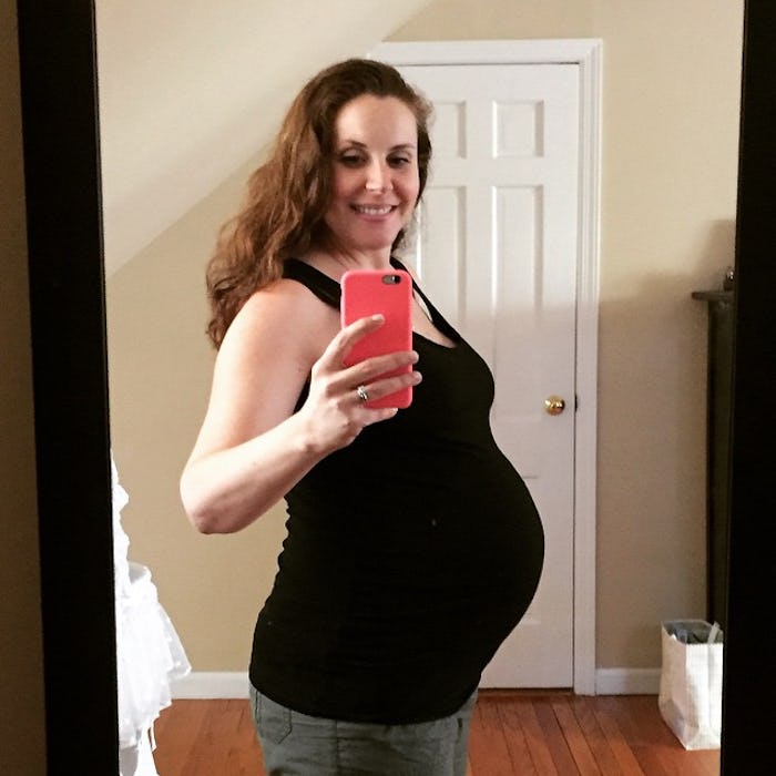 A pregnant woman taking a photo of herself in the mirror