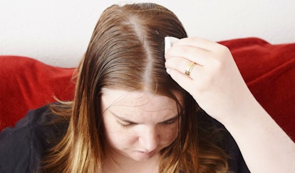 A woman putting lemon juice on her hair