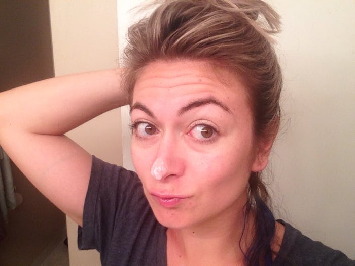 A woman holding her hair up in order to show how her skin looks after applying snail mucus