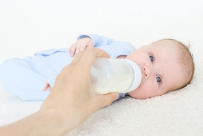 Mother feeding her child with the milk from the bottle