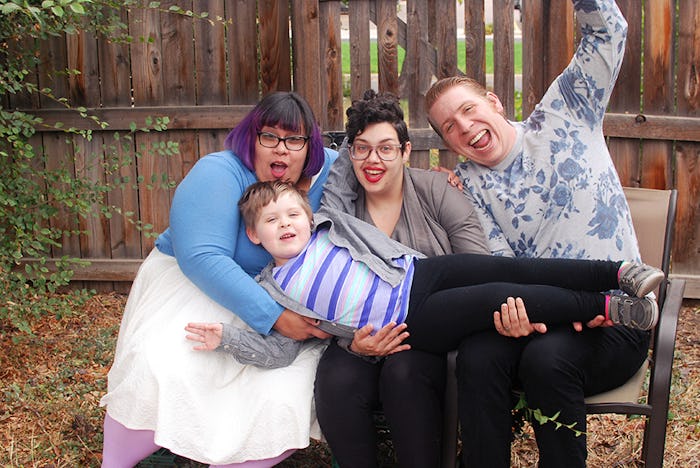 B R Sanders and their family holding their child while sitting in the backyard