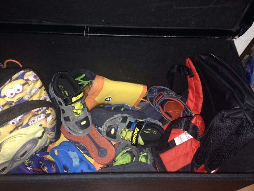 A car trunk full of kid's shoes, toys, and clothes