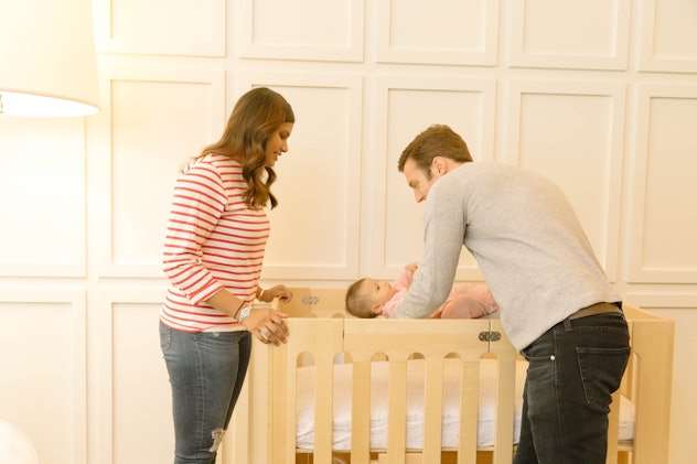 A father putting his baby in a crib