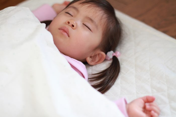 A toddler girl with pigtails sleeping despite toddler sleeping problems