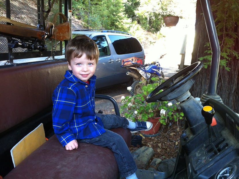 A boy sitting at a steering wheel of a truck