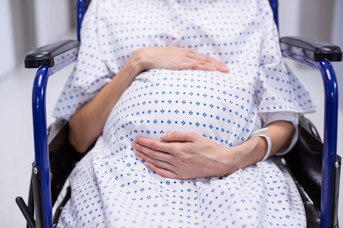 Pregnant woman in labor, sitting in wheelchair at hospital