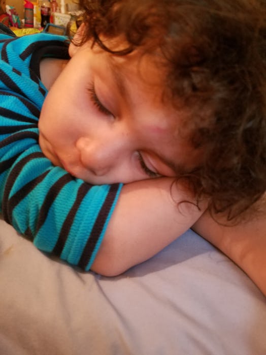 A curly hair toddler taking a nap
