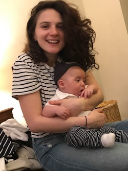 EJ Dickson smiling while holding her baby on her lap