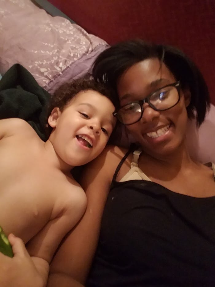 A woman and her son lying next to each other, posing and smiling at the camera