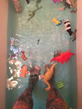 Elle Stanger photographed her feet standing in a tub full of water and dino toys