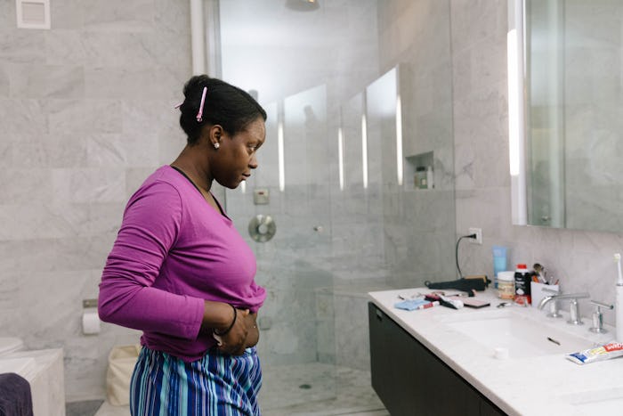 pregnant woman looking in mirror