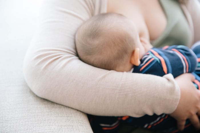 A mother sitting and breastfeeding her baby