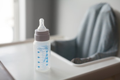 An empty baby bottle on a feeding chair