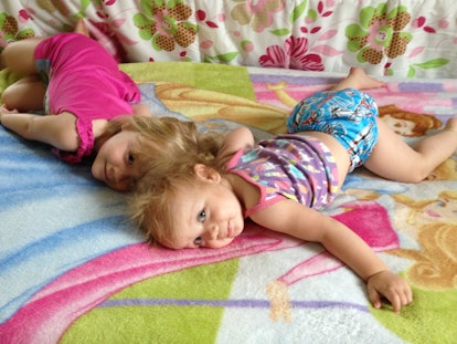 Two little girls lying on a king-sized bed
