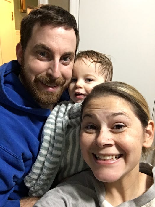 A couple and their toddler smiling while taking a selfie