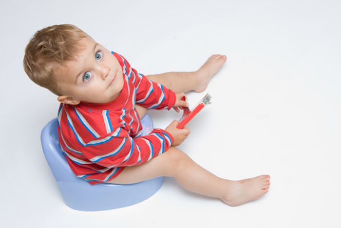 A child sitting on a light blue potty