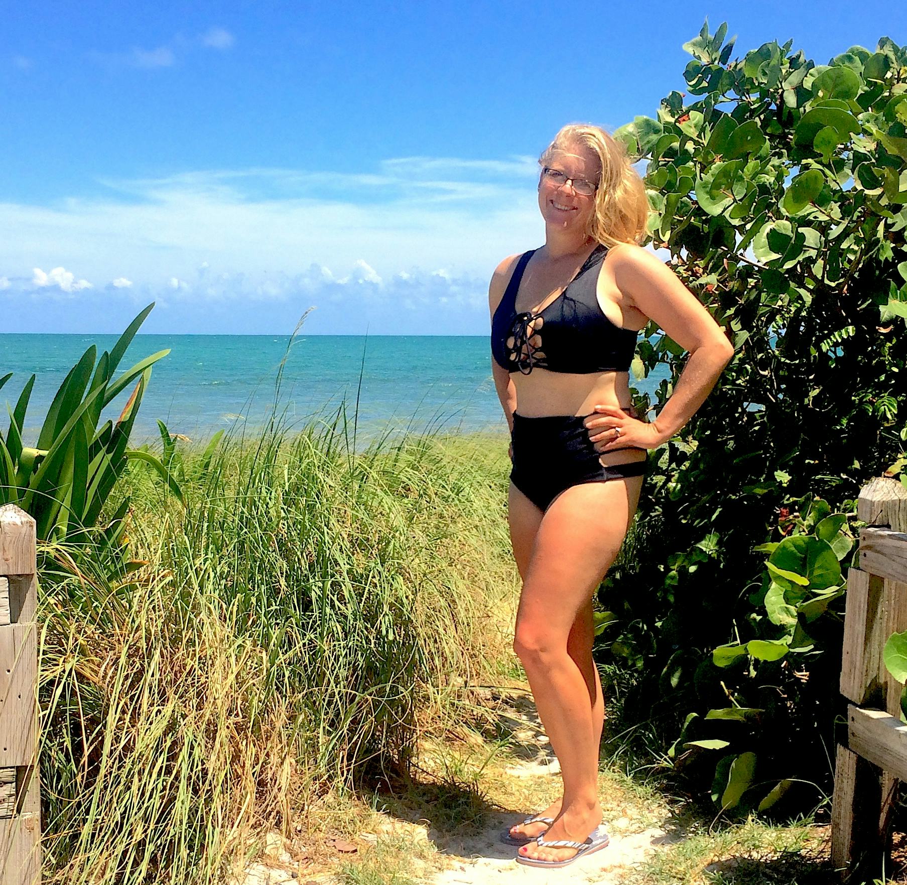 Crystal Henry posing in a black bikini that saved her postpartum 