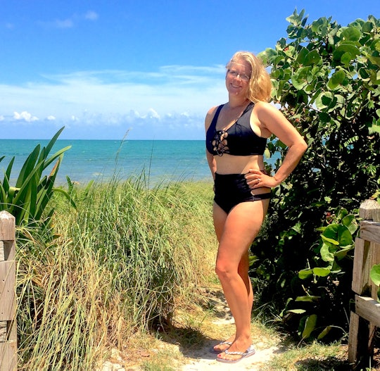 Crystal Henry posing in a black bikini that saved her postpartum 