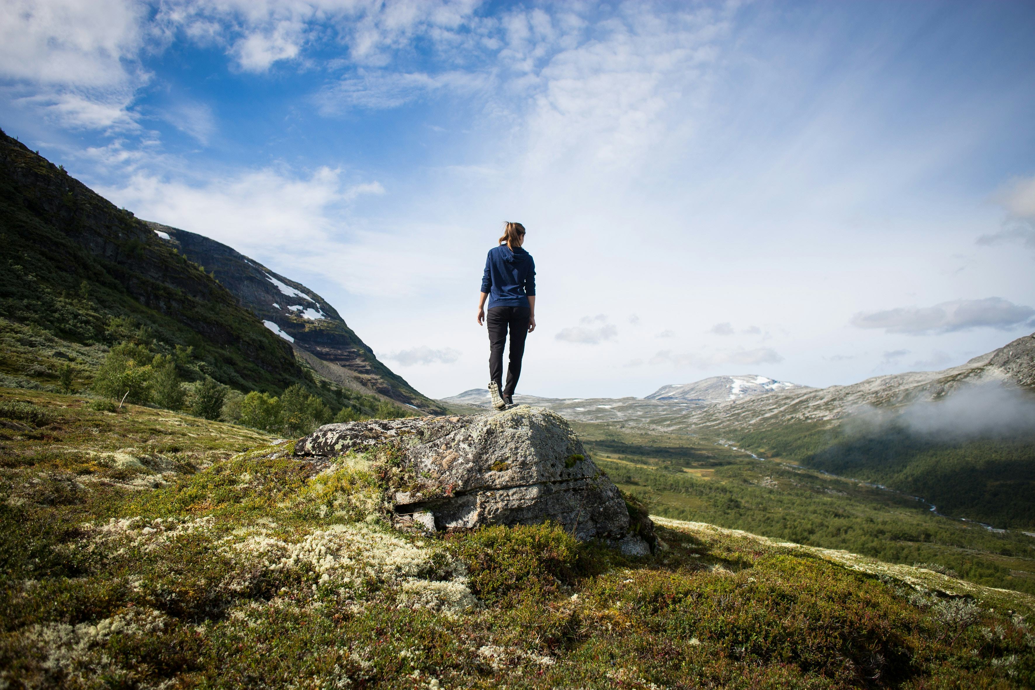 A man standing on a rock after having hiked off the beaten path