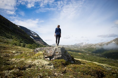 A man standing on a rock after having hiked off the beaten path