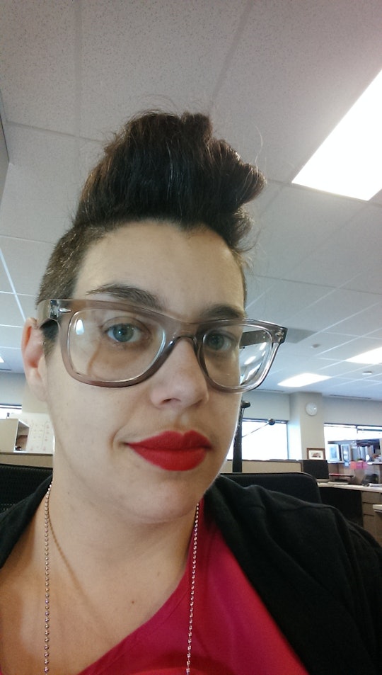 The author B. R. Sanders' wearing a red lipstick and glasses while taking a selfie