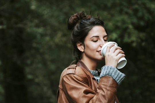 A woman having her coffee-to-go while walking.