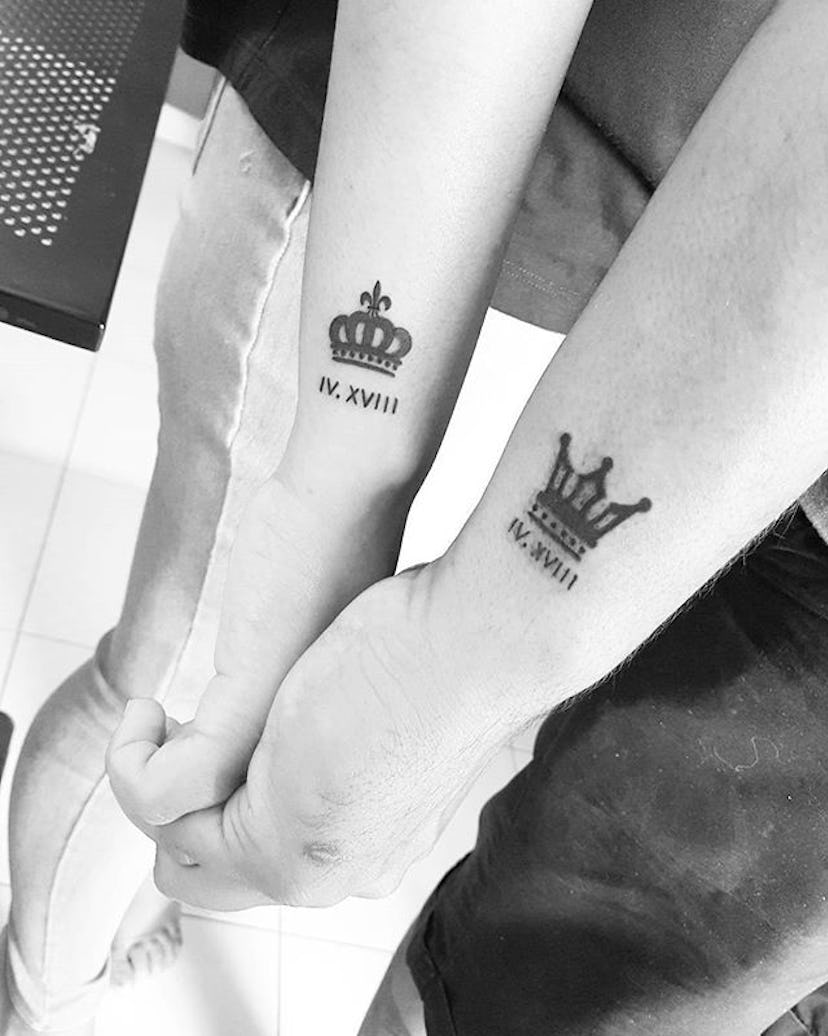 Man and woman with matching crowns with dates tattoos on their wrists