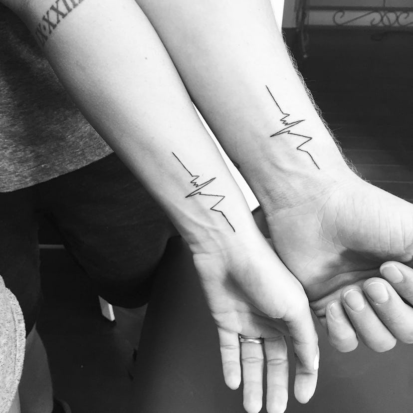 Man and woman with matching heartbeat lines tattoos on their arms