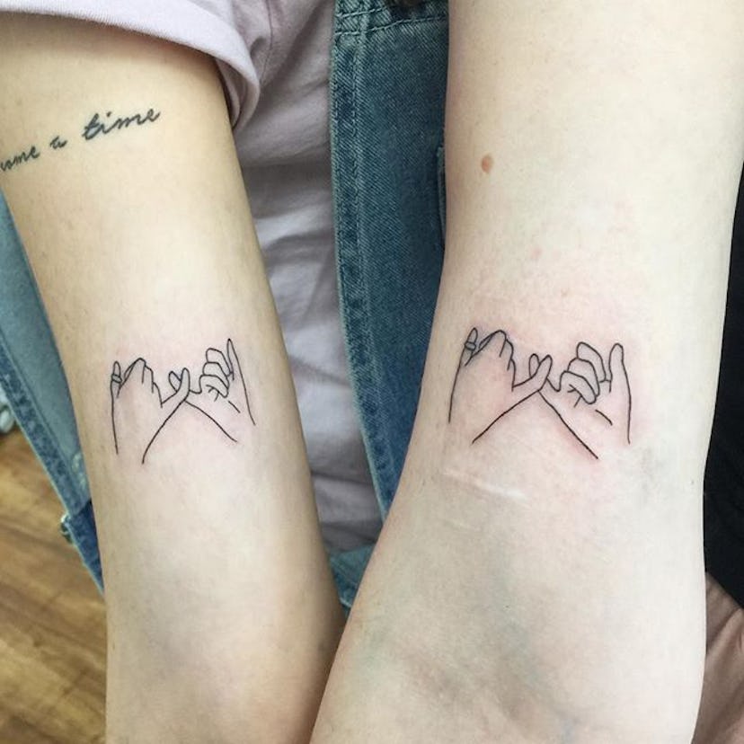 Two friends with matching pinky promise tattoos