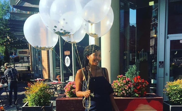 A woman posing with five white balloons
