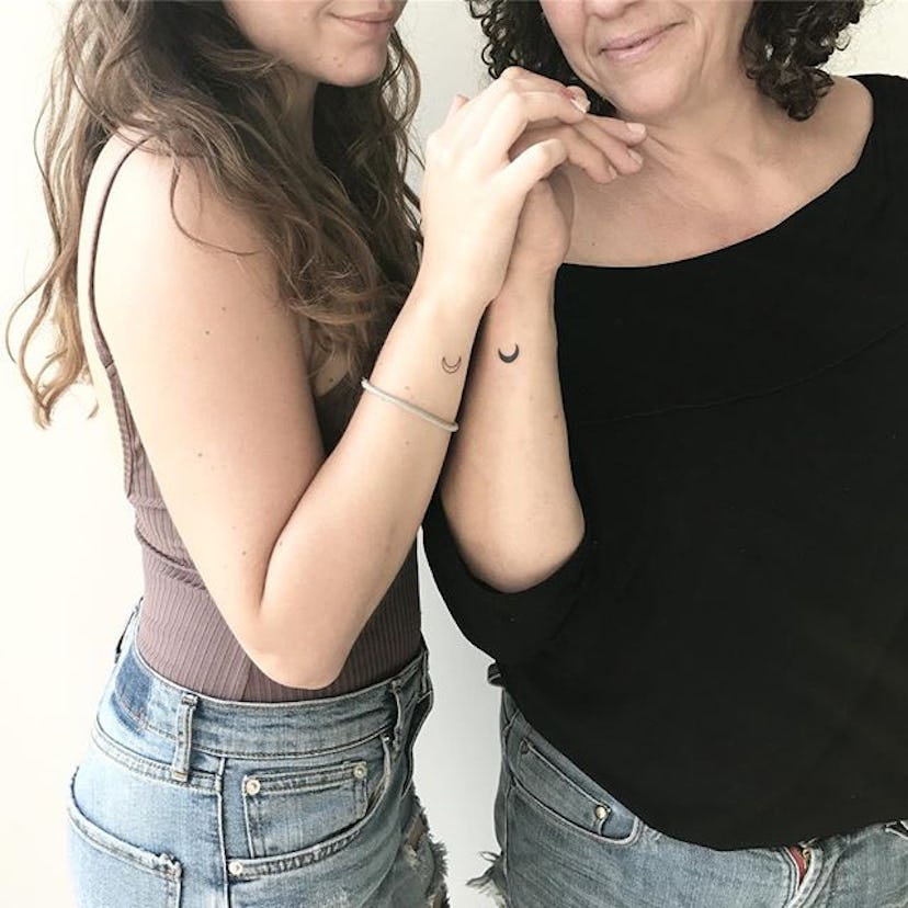 Two women with matching moon tattoos on their wrists