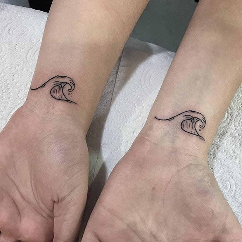 Man and woman with matching wave tattoos on their wrists