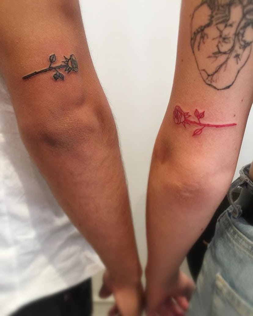 Man and woman with matching rose tattoos on their arms