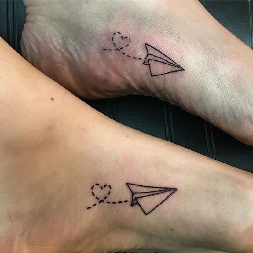 Man and woman with matching paper planes tattoos on their feet