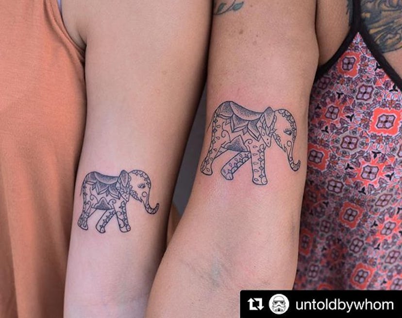 Man and woman with matching elephant tattoos on their hands