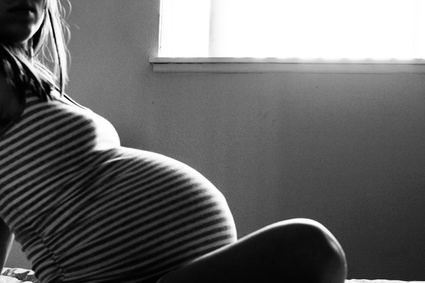 A pregnant woman sitting alone