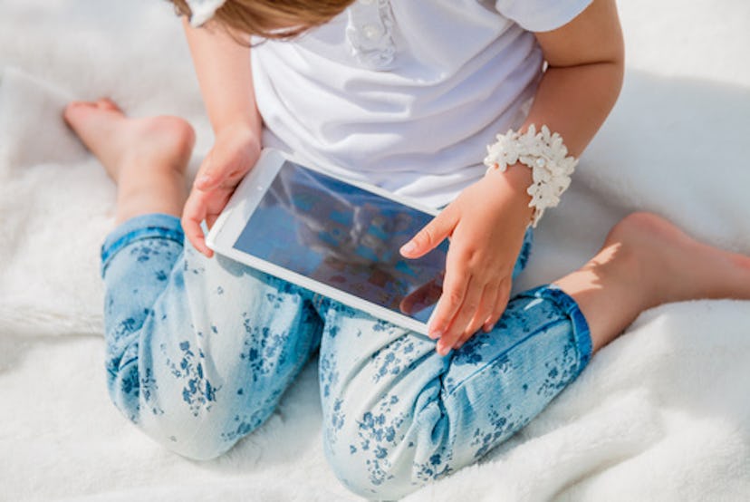 A toddler girl using her screen-time