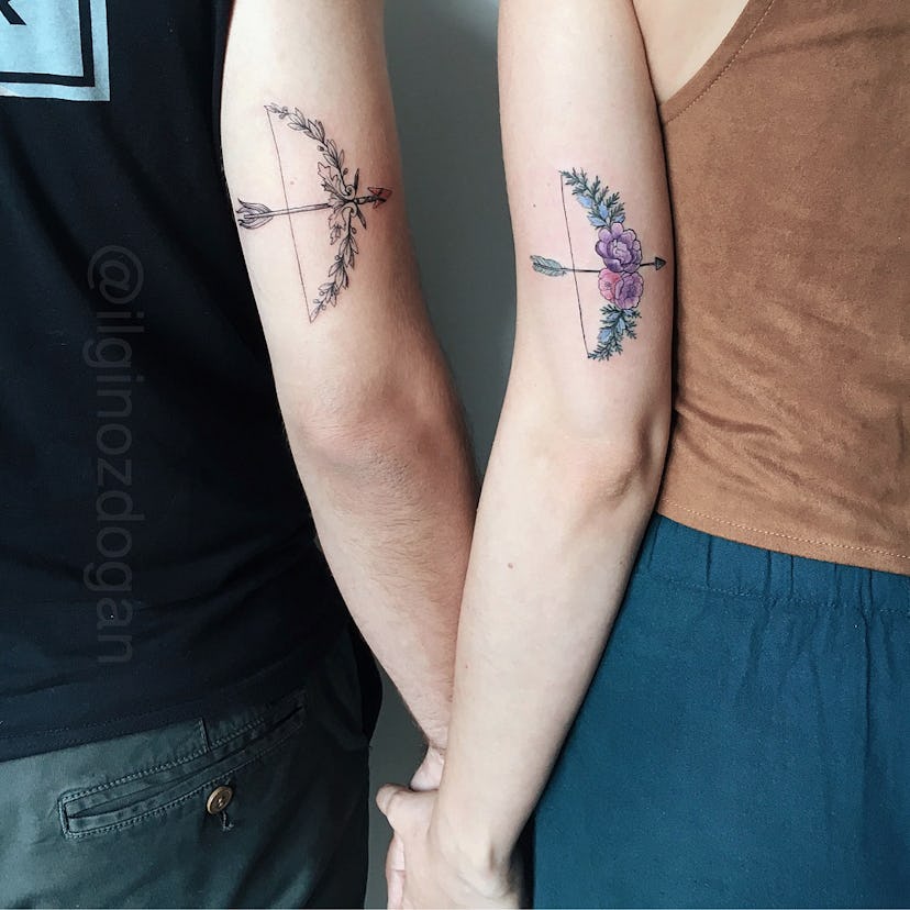 Man and woman with matching bow and arrow tattoos on their arms