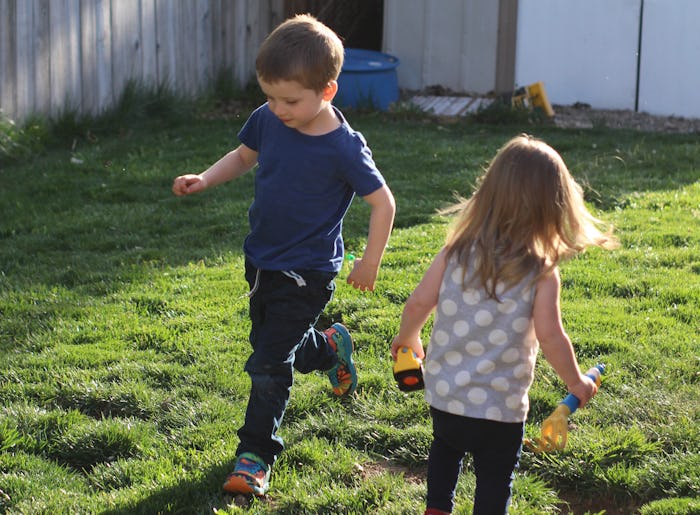 Two kids running in a garden