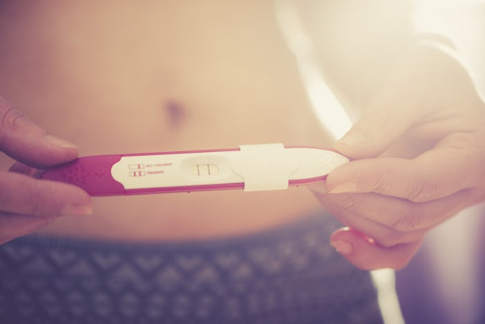 Woman with removed thyroid checking her pregnancy test